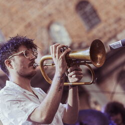 Das Bild zeigt einen jungen Mann mit Trompete.